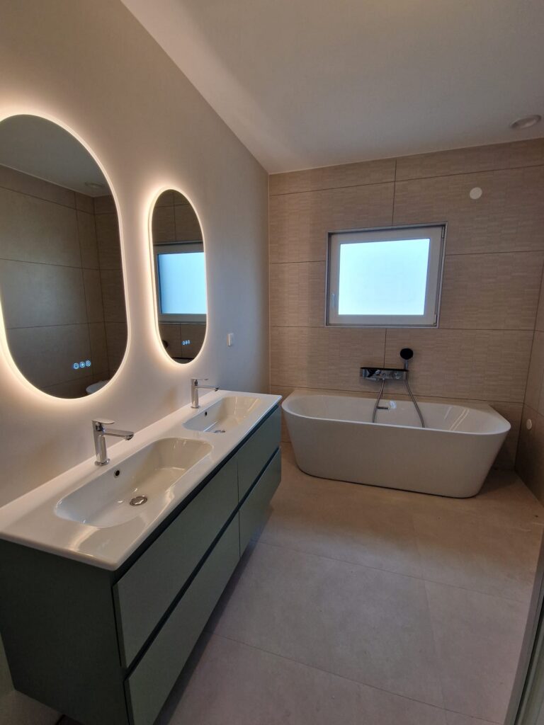 Salle de bain design avec baignoire îlot, double vasque et éclairage LED – réalisation DK Concept chauffage et sanitaire